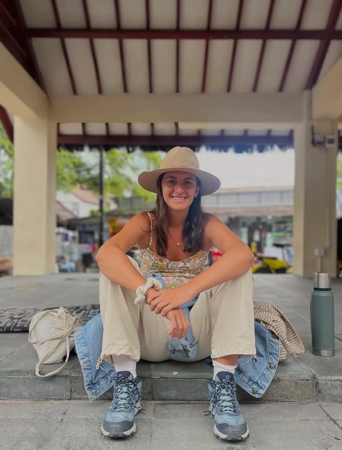 Agos, creadora de las guías, sentada con sombrero y botas de trekking